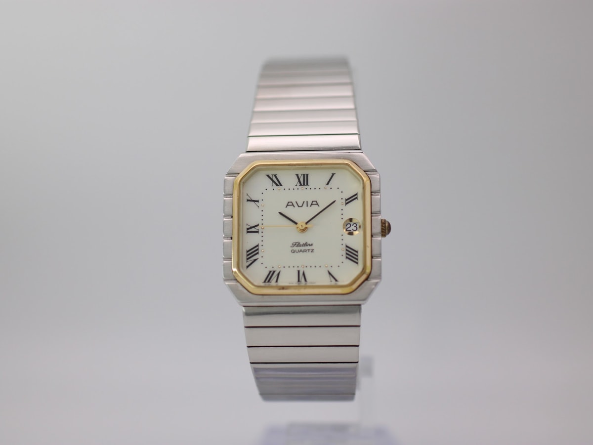 Front view of the AVIA Flatline watch with an octagonal two-tone case, cream dial, and stainless steel expansion bracelet.
