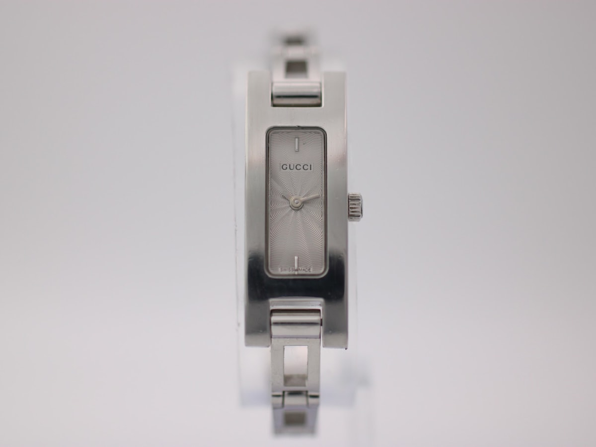 Front view of the Gucci 3900 L watch with a silver rectangular dial and integrated steel bracelet on a white background.