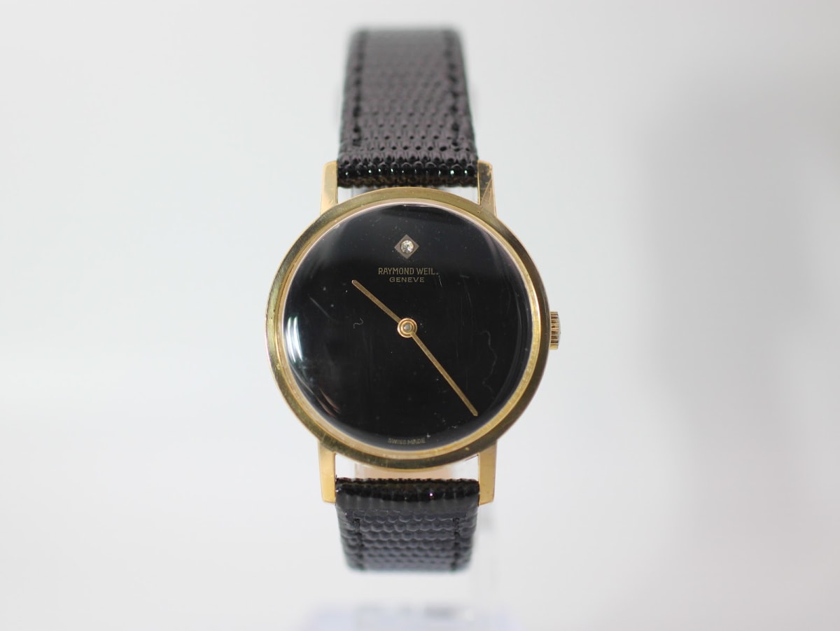 Front view of the gold-tone Raymond Weil 7000 watch with a black dial and black leather strap.