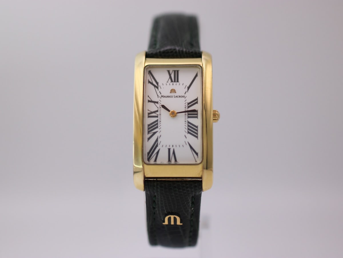 Front view of Maurice Lacroix rectangular gold plated watch with white dial and black Roman numerals, green lizard strap.
