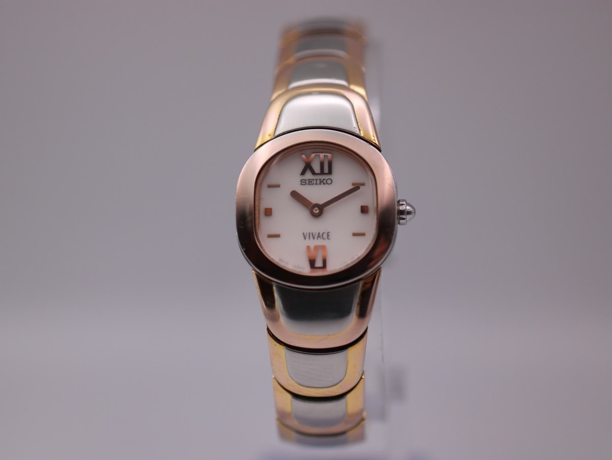 Front view of two-tone Seiko Vivace watch with oval case and white dial.