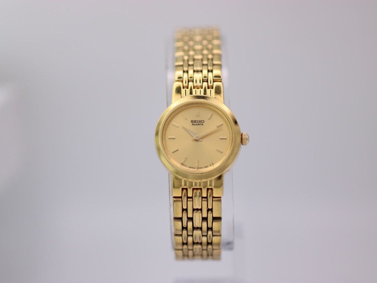 Front view of the gold tone Seiko V400-0368 watch with a gold dial and matching multi-link bracelet.