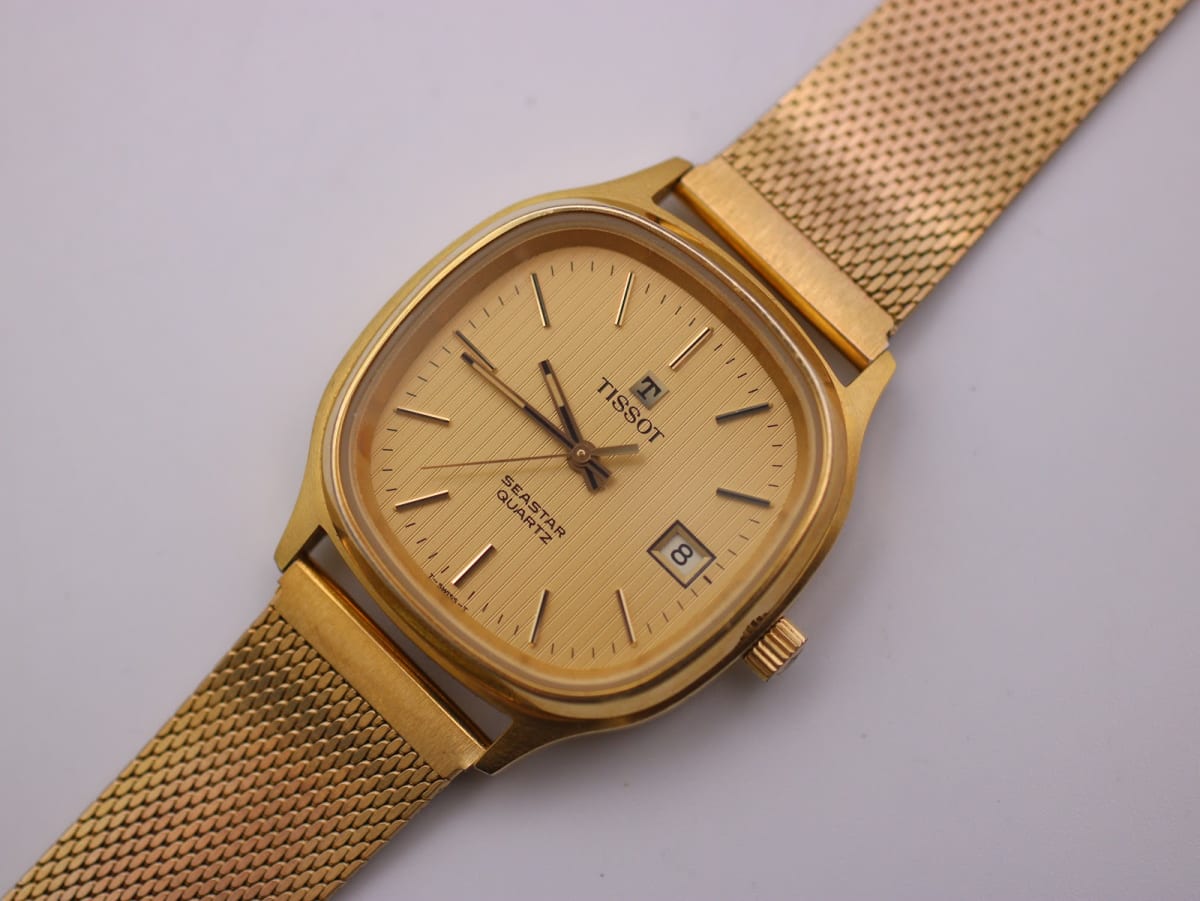 Angled front view of the Tissot Seastar with gold-tone cushion case, champagne dial, and mesh bracelet.