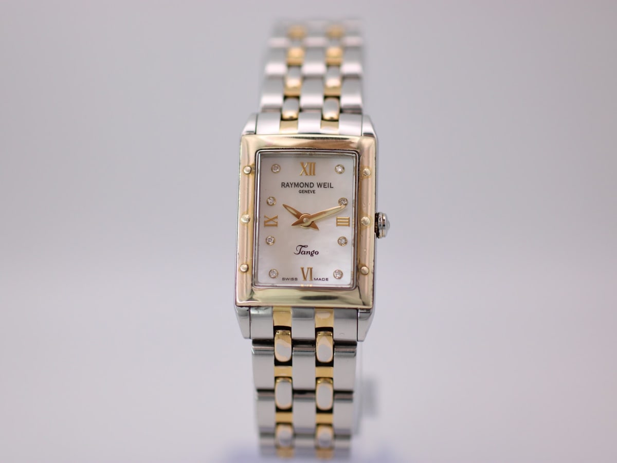 Front view of a two-tone Raymond Weil Tango ladies' watch with a rectangular case and cream mother-of-pearl dial.