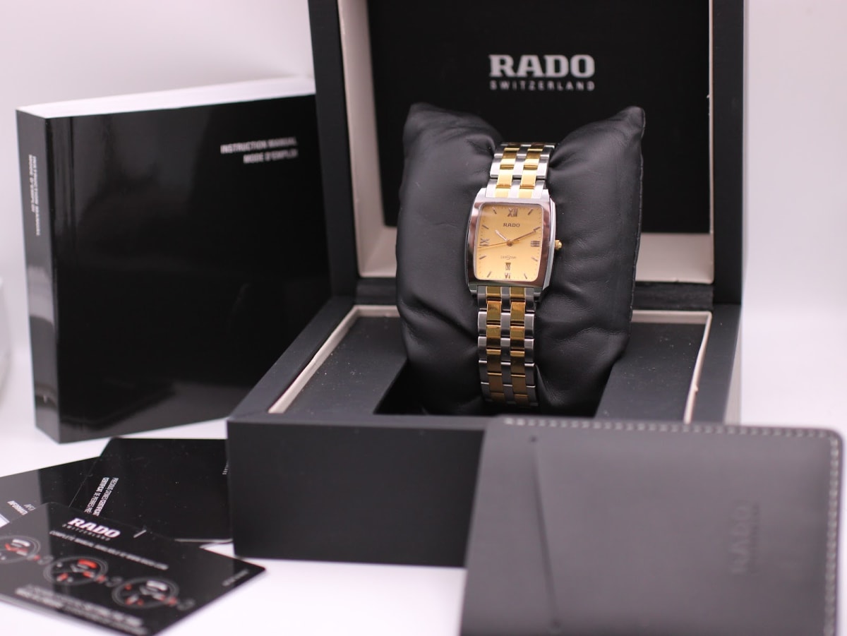 Front view of Rado Diastar two-tone watch with gold dial in its black original Rado presentation box, with papers and instruction manual.