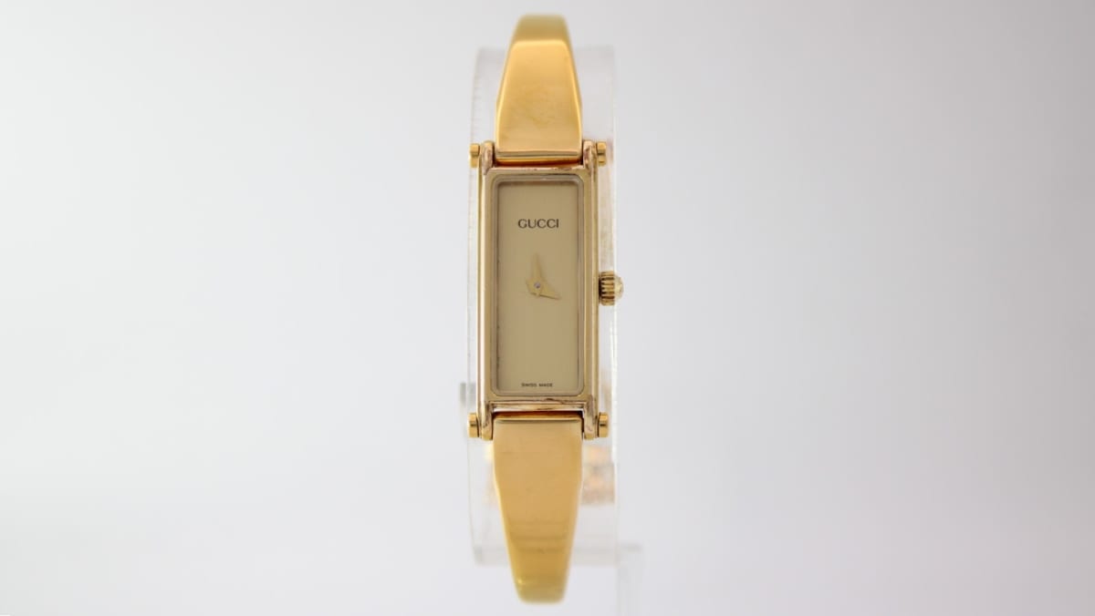 Front view of the gold tone Gucci 1500L watch with champagne rectangular dial.