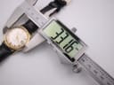 Digital caliper measuring the case diameter of the omega seamaster watch at 33.16mm.
