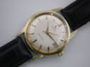 Close-up front view of the omega seamaster dial, showing cream colour, gold baton indices, and date window.