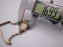 Digital caliper measuring the case diameter of the Omega watch, displaying 16.99mm.