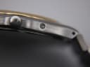 Close-up of the watch case side, showing the brushed finish and a pusher.
