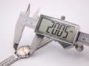 Digital caliper measuring the case diameter of the Omega Ladymatic watch, displaying an exact measurement of 20.05mm.