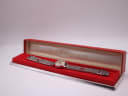 The Omega Ladymatic watch resting inside an open generic red presentation box, labelled 'UNO'.