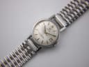 Close-up of the Omega Ladymatic's cream dial, showing applied baton indices, Omega logo, Ladymatic script, and date window.