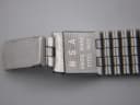 Detailed view of the watch bracelet's clasp, revealing the 'SWISS MADE INOX ACIER UNSA' engravings.