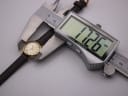 Digital caliper measuring the Omega De Ville case diameter, displaying 17.26mm.