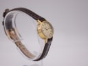 Another side profile view of the Omega De Ville watch on a stand, showing the curved lugs and strap attachment.