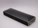 Exterior view of the vintage black watch box, showing wear and textured finish.