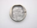 Internal view of the watch case back, engraved with 'LUNETTE PLAQUÉ OR L. 20 MICRONS' and 'FOND ACIER INOXYDABLE'.