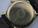 Close-up of the Raymond Weil watch case back, showing surface scratches and engraved model 5360, serial 26543, sapphire crystal, electroplated 10m.