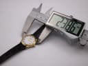 Digital caliper measuring the Raymond Weil watch case diameter, showing a precise reading of 23.86mm.