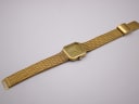 Top-down view of the Santima watch with the gold mesh bracelet fully extended, showing the adjustable clasp.