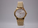 Front view of the Seiko V732-0450 gold-tone quartz watch with white dial, showing textured pattern and date window.