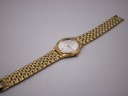 Overhead view of the Seiko gold-tone watch laid flat, displaying the full length of the integrated bracelet.