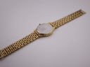 View of the Seiko watch from the rear, showing the stainless steel case back and the full length of the gold-tone integrated bracelet.