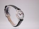 Another angled side view of the Mondaine 3831 watch on a stand, showcasing the sleek profile.