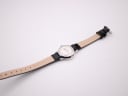 Back view of the Mondaine watch, showing the stainless steel case back and the 'Genuine Leather' embossed strap lining.