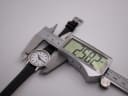Top-down view of the Mondaine watch being measured by a digital caliper, displaying a case size of 29.82mm.