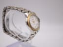 Another angled side view of the Tissot Ballade on a display stand, highlighting the integrated two-tone bracelet design.