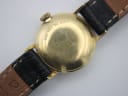 Close-up of the gold-tone case back of the Tissot watch, showing 'USE KEY NO. 200T' engraving and surface scratches.