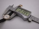 Side view of the Tissot watch being measured by a digital caliper, displaying a precise case diameter of 21.94mm.