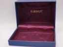 Open original Tissot watch box, showing the dark blue exterior and purple satin interior with the gold Tissot logo.