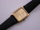 Close-up of the Raymond Weil 5700 watch dial, revealing the minimalist champagne face and gold hands.
