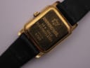 Close-up of the Raymond Weil 5700 case back, engraved with "18 K GOLD ELECTROPLATED" and "10 M QUARZ", showing light surface scratches.