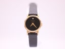 Front view of the Raymond Weil 570 watch with black dial, gold-tone octagonal case, and black leather strap.