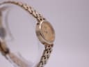 Opposite angled side view of the Tissot watch, highlighting the polished gold-tone case and bracelet links.