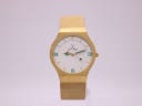Front view of the gold-tone Toy Watch with octagonal case, white dial, and mesh bracelet.