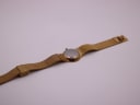 Back view of the full gold-tone Toy Watch laid flat, revealing the stainless steel case back.