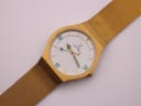 Close-up of the Toy Watch dial, showing the white face, green numerals and hands, and gold indices.