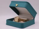 The gold-tone Seiko 5 watch presented in its original teal-coloured watch box with a gold crown emblem.