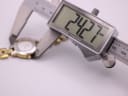 Digital caliper measuring the case diameter of the Tissot G330, displaying 24.27mm precisely.