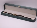 The Raymond Weil watch neatly placed inside its original dark green presentation box, with a cream-coloured interior.