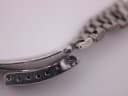 Close-up of the vintage SEIKO watch's folding clasp, showing adjustment holes and signs of wear.