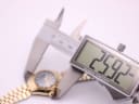 Digital caliper display showing the watch case diameter as 25.92mm, with the watch blurred in the background.