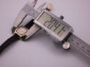 Digital caliper measuring the case diameter of the Citizen watch, displaying a precise reading of 20.4mm.