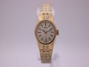 Front view of the gold-tone Seiko ladies watch with a silver textured dial and integrated bracelet, on a clear stand.