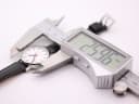 Digital caliper measuring the case diameter of the Mondaine watch, showing a reading of 25.96mm.